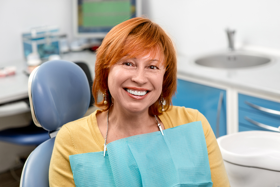 red haired woman smiling nice teeth, sitting in dental office chair, North Syracuse, NY cosmetic dentistry